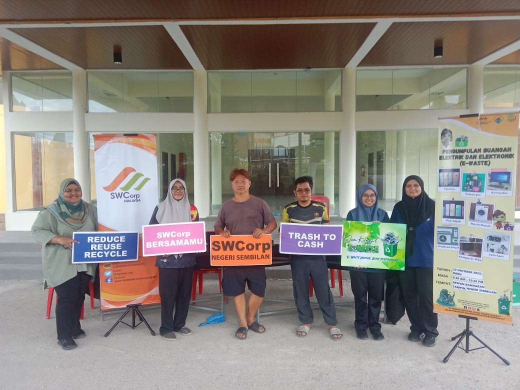 Team holding Trash to Cash programme signs